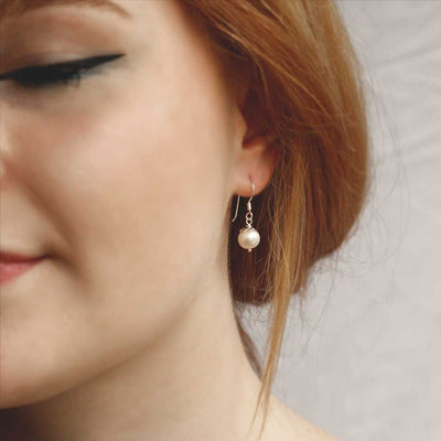 MK803E STERLING SILVER ROUND PEARL DANGLY EARRINGS MODEL SHOT 1110X1110
