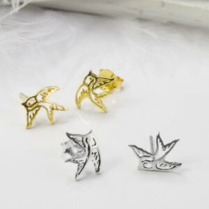 Small Gold Swallow Bird studs behind Small Silver Swallow Bird studs with white feather background