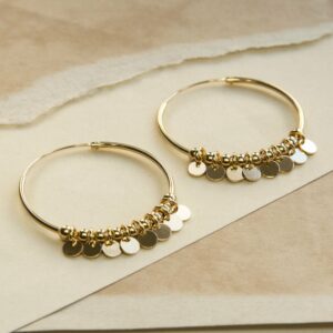 Gold Hoops with sequin detail on a ripped, sandy coloured paper background