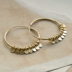 Gold Hoops with sequin detail on a ripped, sandy coloured paper background