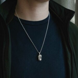 man wearing t rex skull necklace with jacket