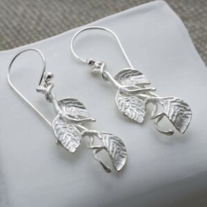 silver three leaves on branch dangly earrings laid straight