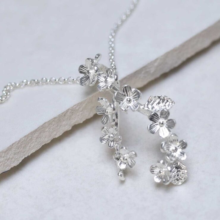 Sterling Silver Forget Me Not Cluster Necklace on stone