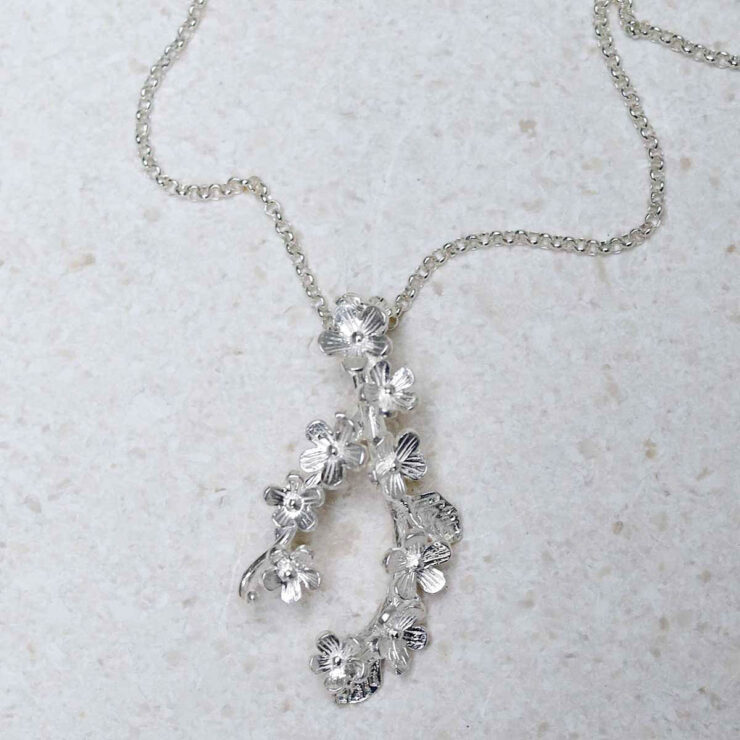 Sterling Silver Forget Me Not Cluster Necklace on stone