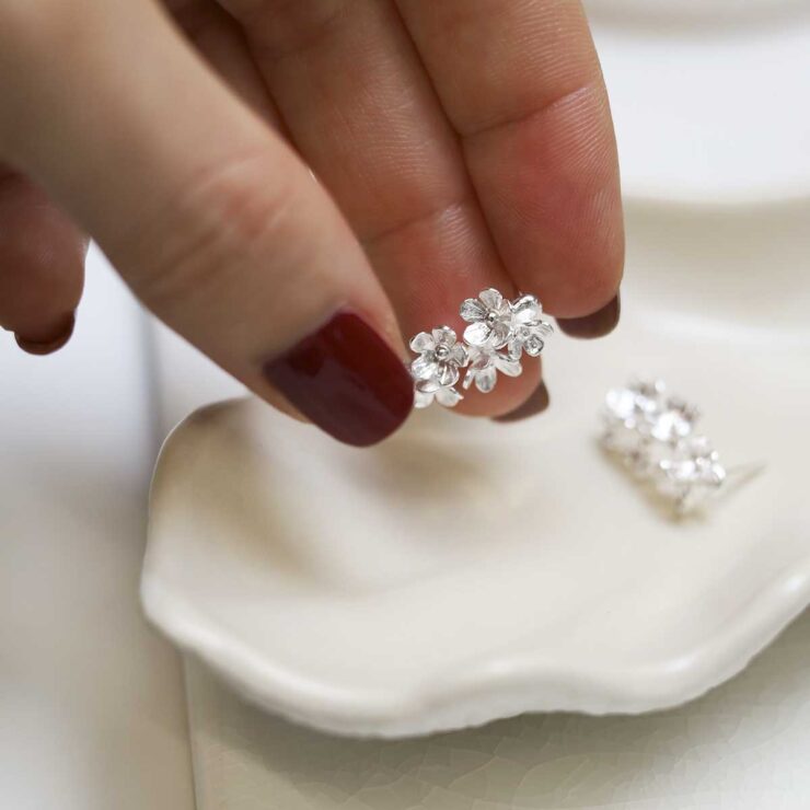 model holding Sterling Silver Forget Me Not Drop Earrings