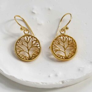 Gold Tree earrings on textured white backgrounds