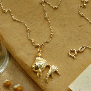 Gold Fish Necklace on brown background