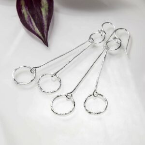 Silver rings on double hanging bar earrings