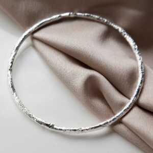 Sterling Silver Textured Bark bangle on beige material