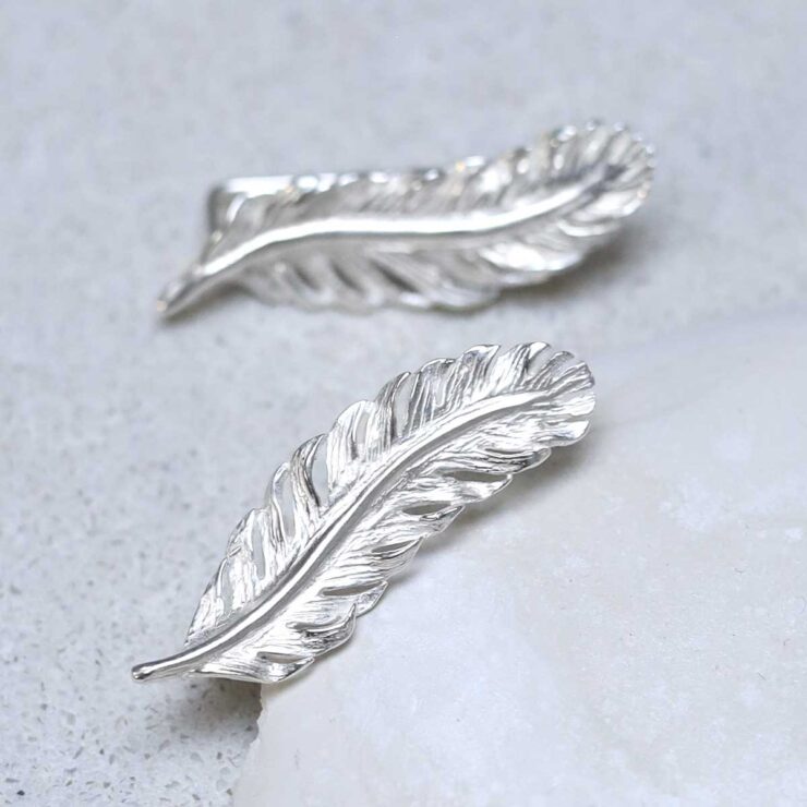 Sterling Silver Feather Ear Climbers on stone