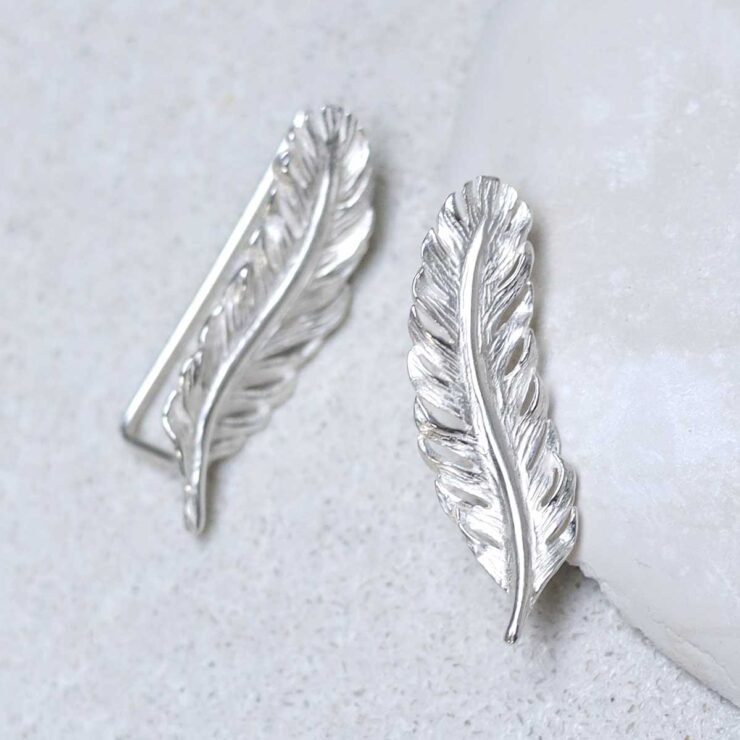 Sterling Silver Feather Ear Climbers on stone
