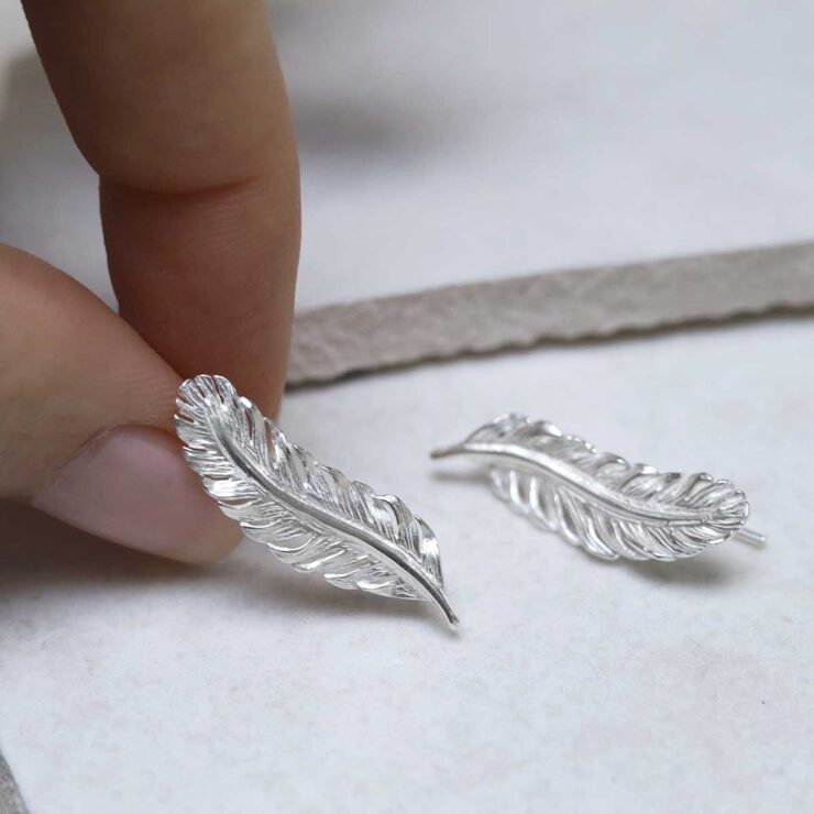 Sterling Silver Feather Ear Climbers held by model