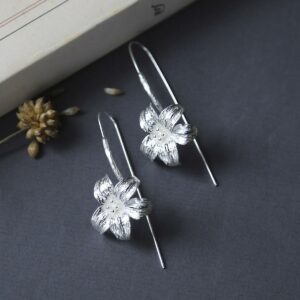 Large silver lily earrings featuring a long silver stem threaded through the ear