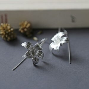 Large silver lily earrings featuring a long silver stem threaded through the ear