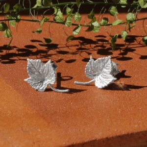 Silver Ivy Leaf Earrings with Terracotta background and little Green Leaves in background