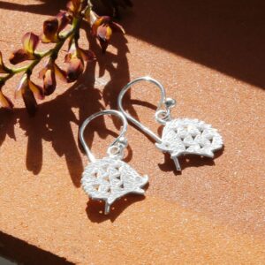 Silver Hedgehog Drop Earrings with a Brick Textured Background With Dried Flowers