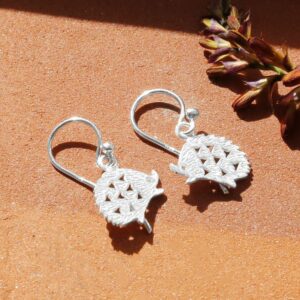 Silver Hedgehog Drop Earrings with a Brick Textured Background With Dried Flowers