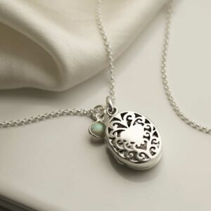 Sterling Silver Vintage Oval Locket with add on charm, on cream background with silk detail