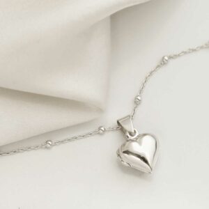 Sterling Silver Tiny Heart Locket Necklace with satellite chain on white background with silk detail