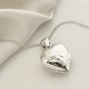 Sterling Silver Four Piece Heart Locket Necklace on silk background