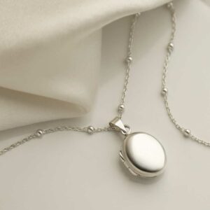 Sterling Silver Little Oval Locket on silk background with satellite chain