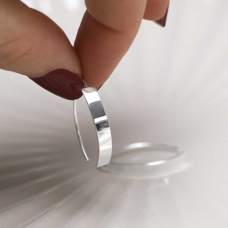 model holding Sterling Silver Urban Shield Drop Earrings