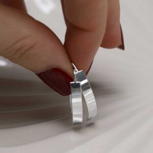 model holding Sterling Silver Urban Shield Drop Earrings