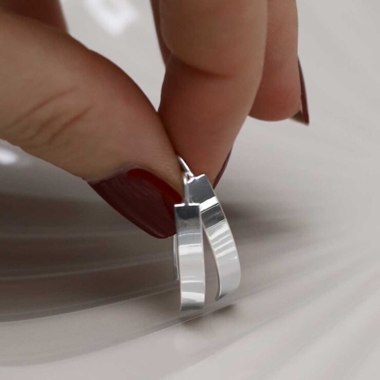 model holding Sterling Silver Urban Shield Drop Earrings