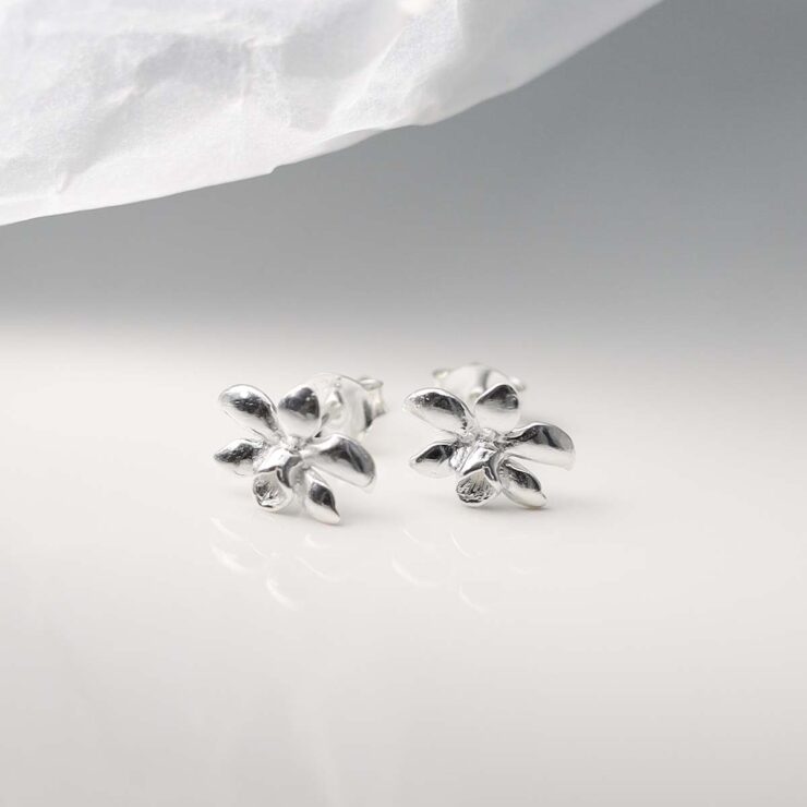 Sterling Silver Daffodil Stud Earrings on ceramic background