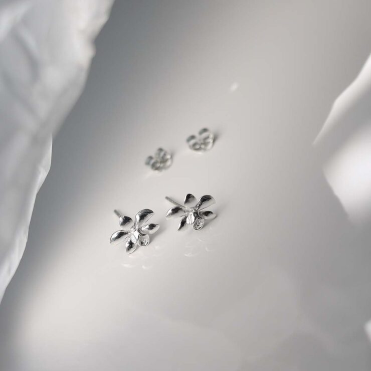 Sterling Silver Daffodil Stud Earrings on ceramic background