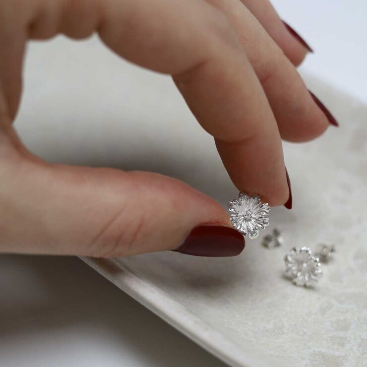 model holding Sterling Silver Cosmos Flower Studs