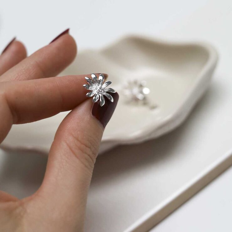 model holding Sterling Silver Polished Daisy Stud Earrings