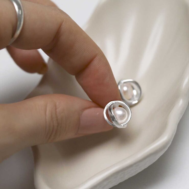 model holding Sterling Silver Designer Round Pearl Studs