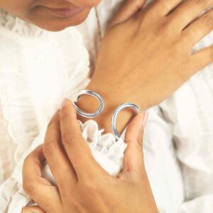 Model In White Blouse Wearing Sterling Silver Oval Loop Bangle