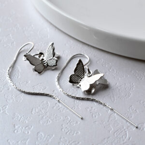 Butterfly chain earrings on white background