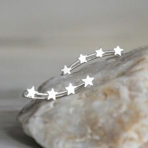 Silver 4 star ear climbers on a stone background