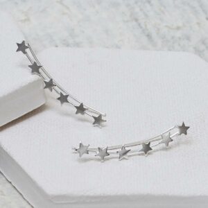 Silver 6 star ear climbers on white plaster hexagon