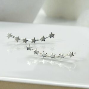 Silver 6 star ear climbers on white glossy tile