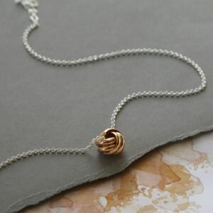 Rose Gold Sterling Silver Forever Knot Necklace on grey background