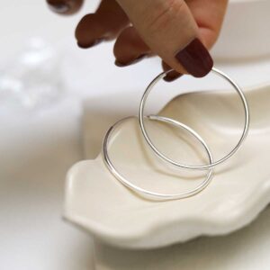 model holding Sterling Silver 45mm Hoop Earrings