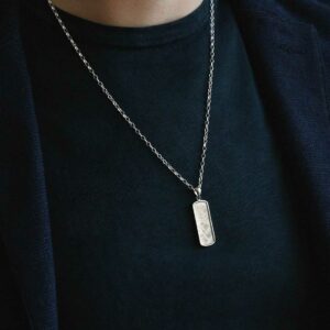 man wearing rounded rectangular meteorite necklace framed with silver