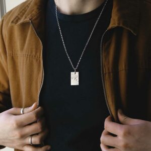 man holding lapels wearing meteorite rectangle necklace