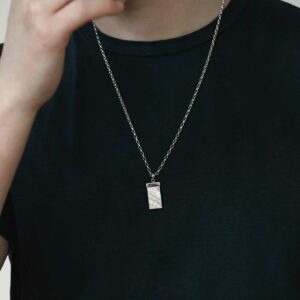 man wearing rectangular meteorite slice capped with silver on chain