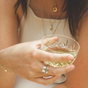 Self care spinner ring on model holding glass of beverage