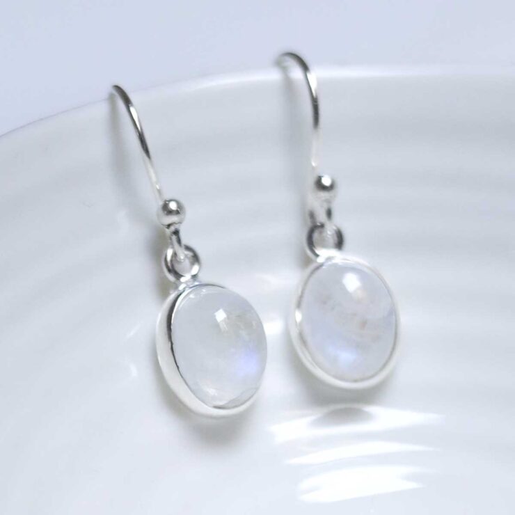 Sterling Silver Dangly Moonstone Oval Earrings on white dish