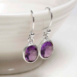 Sterling Silver Dangly Amethyst Oval Earrings on white dish
