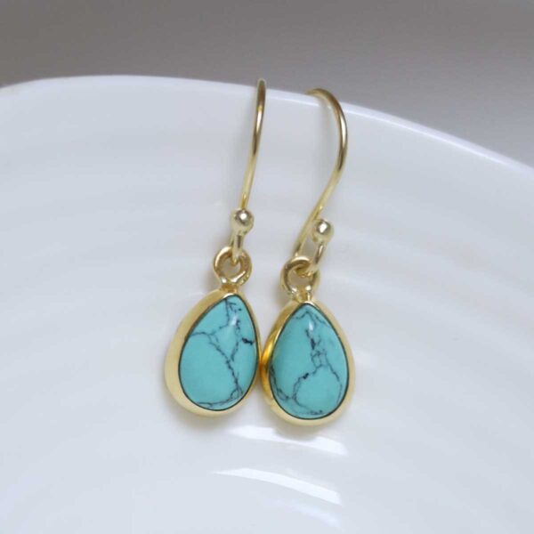Sterling Silver Gold Plated Turquoise teardrop earrings on white dish