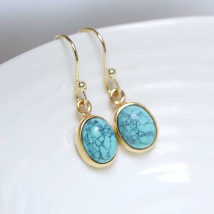 Sterling Silver Gold Plated Turquoise oval earrings on white dish