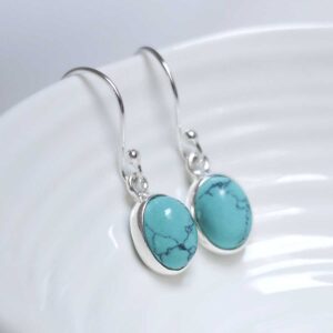 Sterling Silver Dangly Turquoise Oval Earrings on white dish