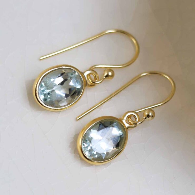 Sterling Silver Gold Plated Dangly Blue Topaz Oval Earrings on white